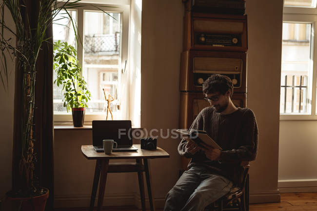 Чоловік читає книгу у вітальні вдома — стокове фото