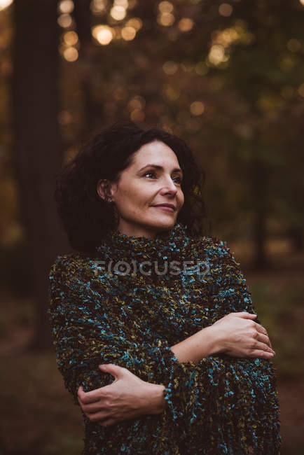 Усміхнена зріла жінка стоїть в лісі — стокове фото