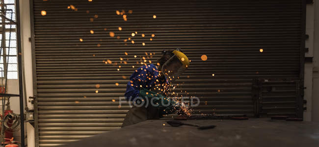 Female welder using welding torch in workshop. — Stock Photo