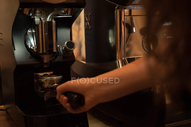 Garçonete segurando portafilter preenchido com café moído no café — Fotografia de Stock