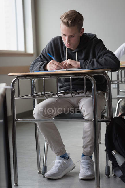 Teenage boy studying in classroom at university — Stock Photo