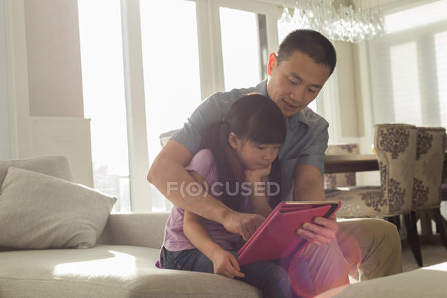 Батько і дочка використовують цифровий планшет вдома — стокове фото