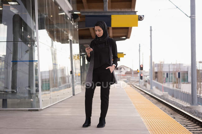 Frau im Hidschab benutzt Handy am Bahnhof — Stockfoto