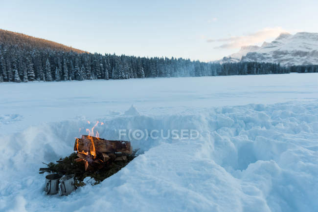 Lagerfeuer in verschneiter Landschaft im Winter in revelstoke, Britisch Columbia, Kanada. — Stockfoto