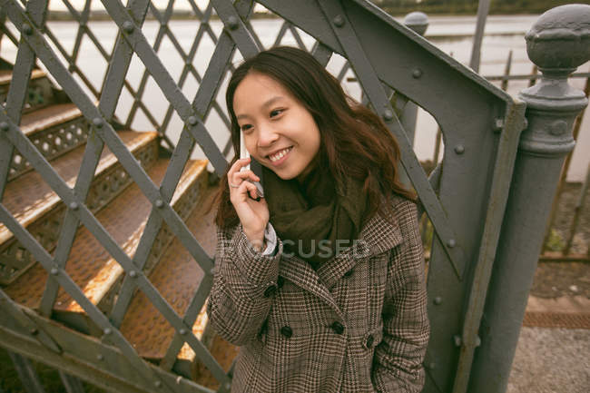 Красива жінка розмовляє на мобільному телефоні на залізничній платформі — стокове фото
