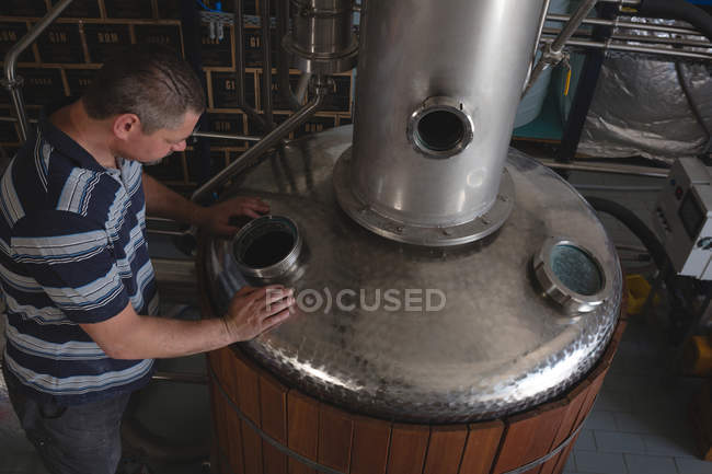 Male worker checking machine of distillery in factory — Stock Photo