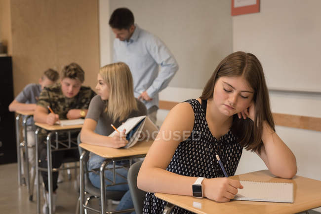 Thoughtful teenage girl sitting in classroom at university — Stock Photo