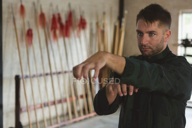 Kung fu fighter practicing martial arts in fitness studio. — Stock Photo