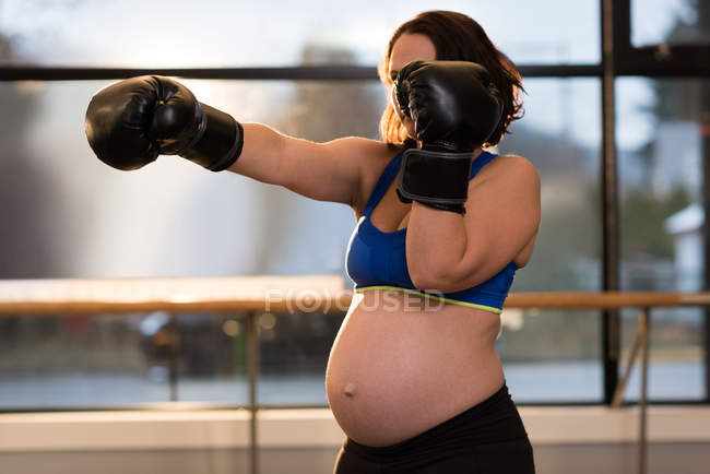 Donna incinta che pratica la boxe in soggiorno a casa — Foto stock