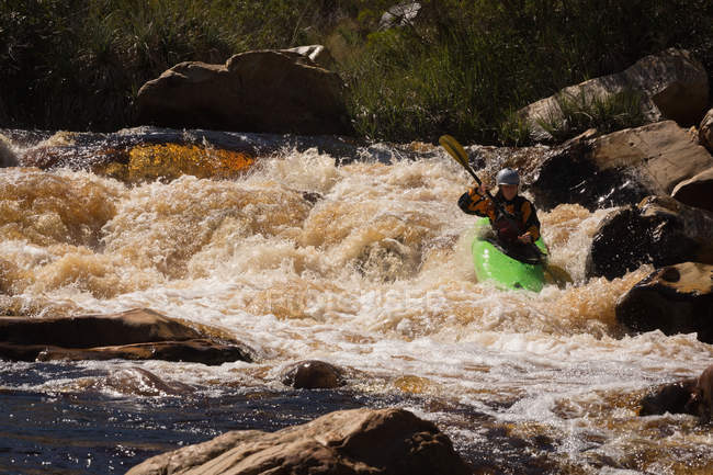 Mulher de caiaque na água do rio da montanha à luz do sol . — Fotografia de Stock