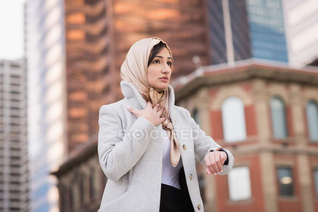 Junge Frau im Hidschab kontrolliert Zeit im Freien — Stockfoto