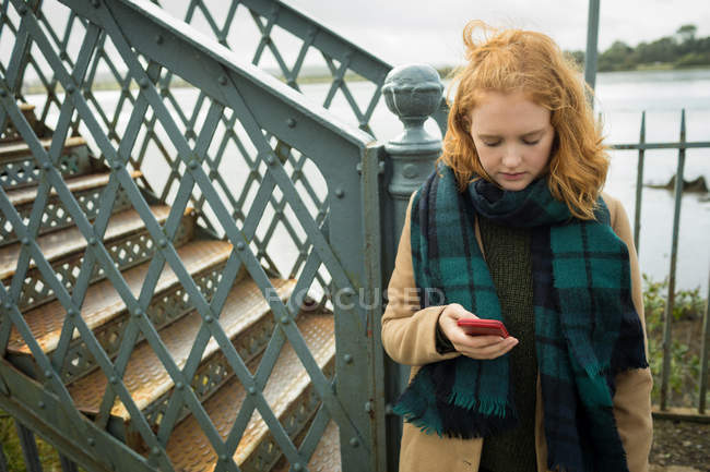 Молода жінка використовує мобільний телефон на залізничній станції — стокове фото
