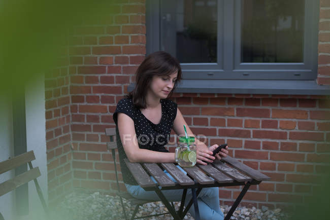 Jovem mulher usando telefone celular — Fotografia de Stock