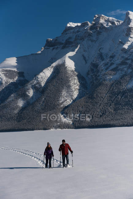 Paar beim Schneeschuhwandern in winterlicher Berglandschaft. — Stockfoto