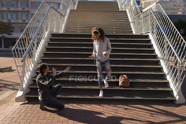 Fotógrafo tirar fotos de um modelo na rua em um dia ensolarado — Fotografia de Stock