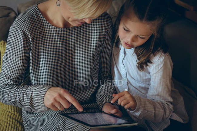 Madre e figlia utilizzando tablet digitale a casa — Foto stock