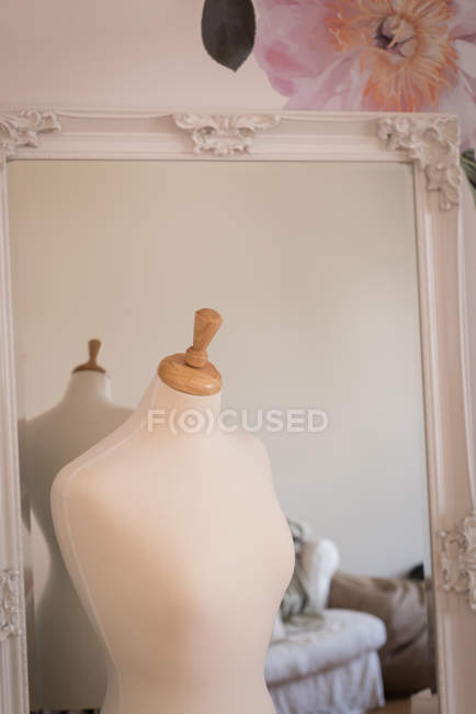Манекен перед зеркалом в дизайнерской студии . — стоковое фото