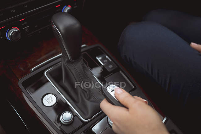 Close-up de executivo feminino usando o controle remoto do carro em um carro — Fotografia de Stock