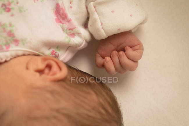 Обрізаний вид новонародженої дитини спить на дитячому ліжку вдома — стокове фото