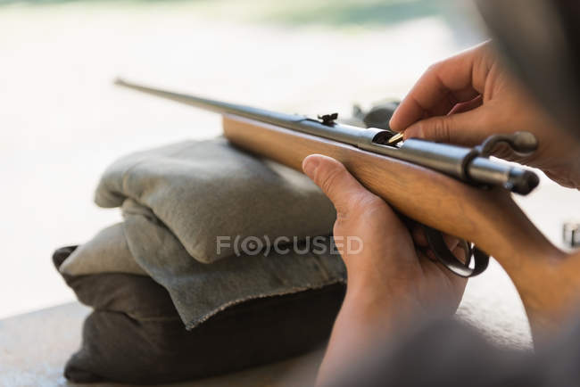 Primer plano del hombre cargando bala en la escopeta - foto de stock