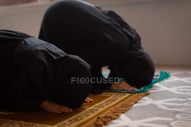 Mãe muçulmana e filha rezando salah em casa — Fotografia de Stock
