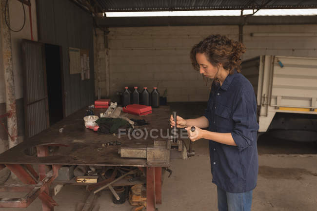 Seitenansicht einer Arbeiterin, die in der Werkstatt arbeitet — Stockfoto