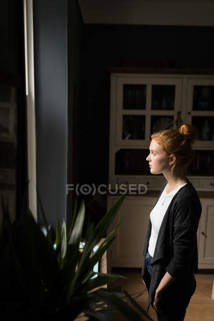 Vista lateral de la mujer reflexiva mirando hacia fuera - foto de stock