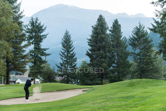 Golfer hitting a golf shot in the course — Stock Photo