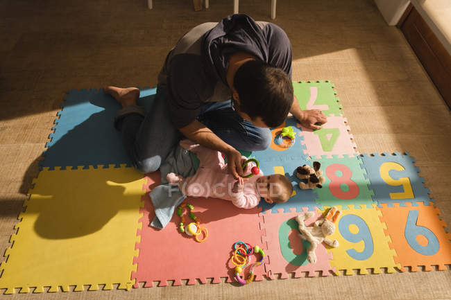 Вид сверху на отца, играющего с мальчиком на полу дома . — стоковое фото