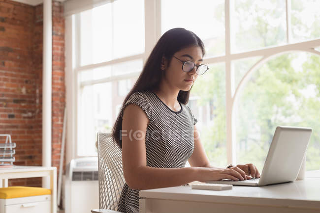 Executivo feminino usando laptop no escritório — Fotografia de Stock