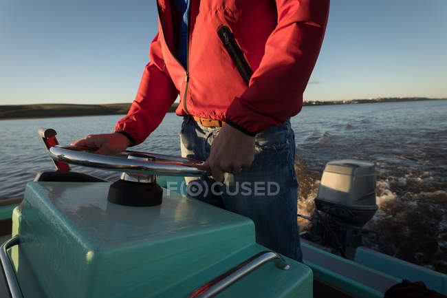 Середина людини їде на моторному човні в річці . — стокове фото