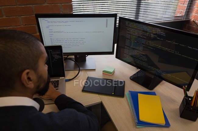 Esecutivo maschile che lavora su laptop alla scrivania in ufficio — Foto stock