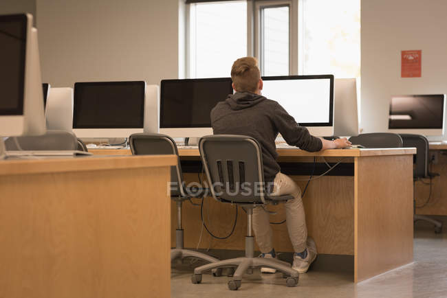 Vista posteriore di adolescente che studia in aula computer all'università — Foto stock