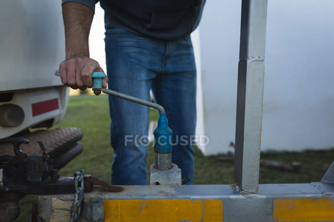 Mid section of man repairing motor boat in backyard. — Stock Photo