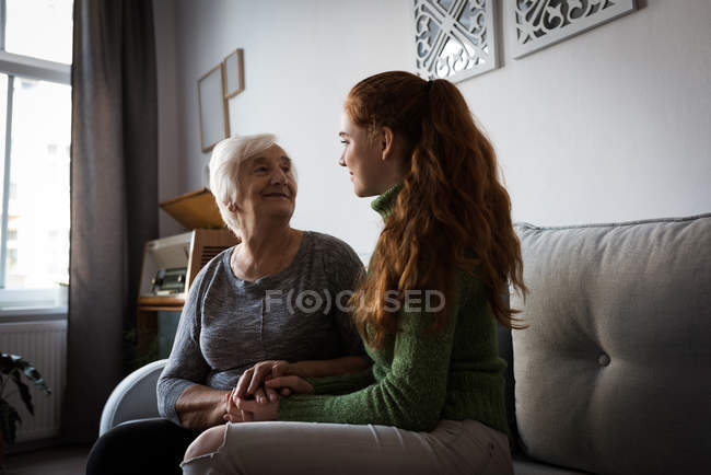 Бабушка и внучка общаются в гостиной дома — стоковое фото