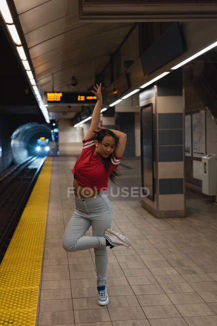 Female street dancer dancing on platform at railway station — Stock Photo