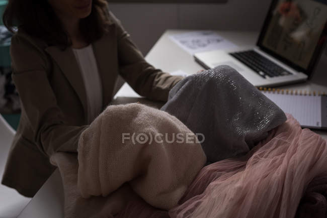 Средняя секция модного дизайнера проверяет ткань в дизайнерской студии . — стоковое фото