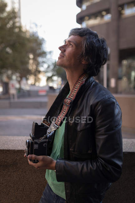 Thoughtful photographer with camera near street — Stock Photo