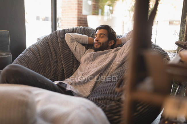 Homem relaxante na cadeira de braço no café — Fotografia de Stock