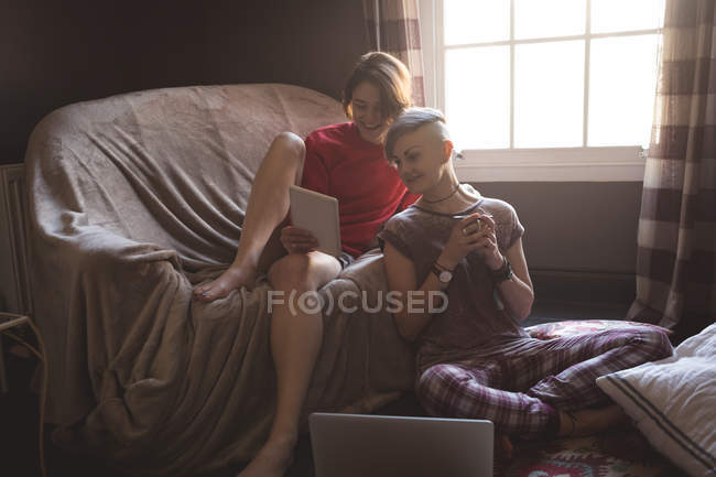 Молоді жінки використовують цифровий планшет у вітальні вдома . — стокове фото