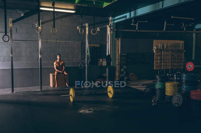 Мускулистый человек расслабляется во время тренировки в фитнес-студии — стоковое фото