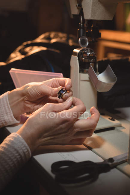 Close-up of tailor holding thread reel at workshop — Stock Photo