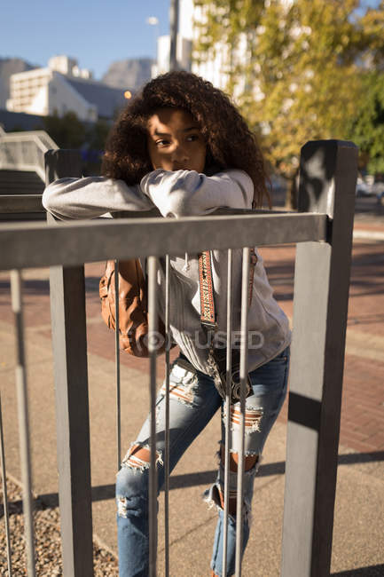 Mulher pensativa apoiando-se em trilhos na rua — Fotografia de Stock