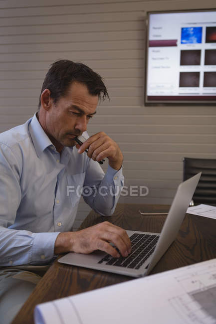 Бізнесмен використовує ноутбук в кімнаті для переговорів в офісі . — стокове фото