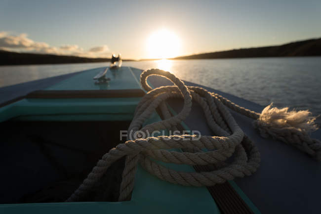 Close-up de corda em barco a motor no rio ao pôr do sol . — Fotografia de Stock
