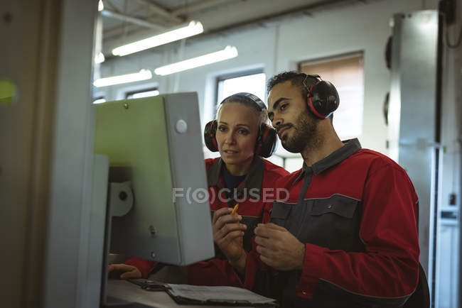 Two workers discussing with each other in factory — Stock Photo