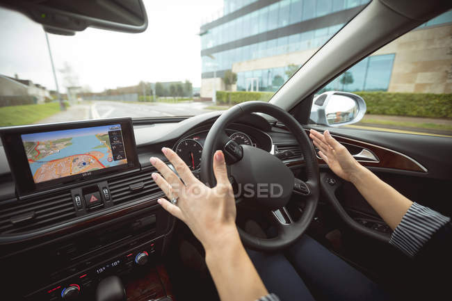 Close-up of female executive driving car on the street — Stock Photo