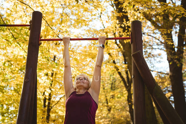 Senior woman practicing exercise in the park on a sunny day — Stock Photo