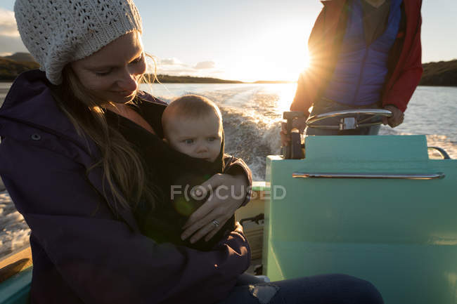 Madre con bambino e padre che viaggiano in barca a motore durante il tramonto
. — Foto stock