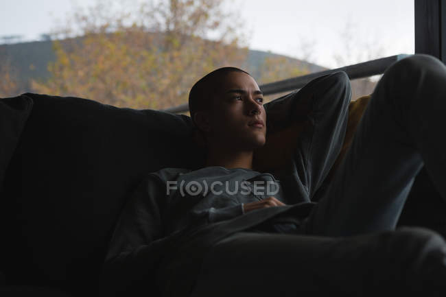 Hombre joven relajándose en la sala de estar en casa - foto de stock